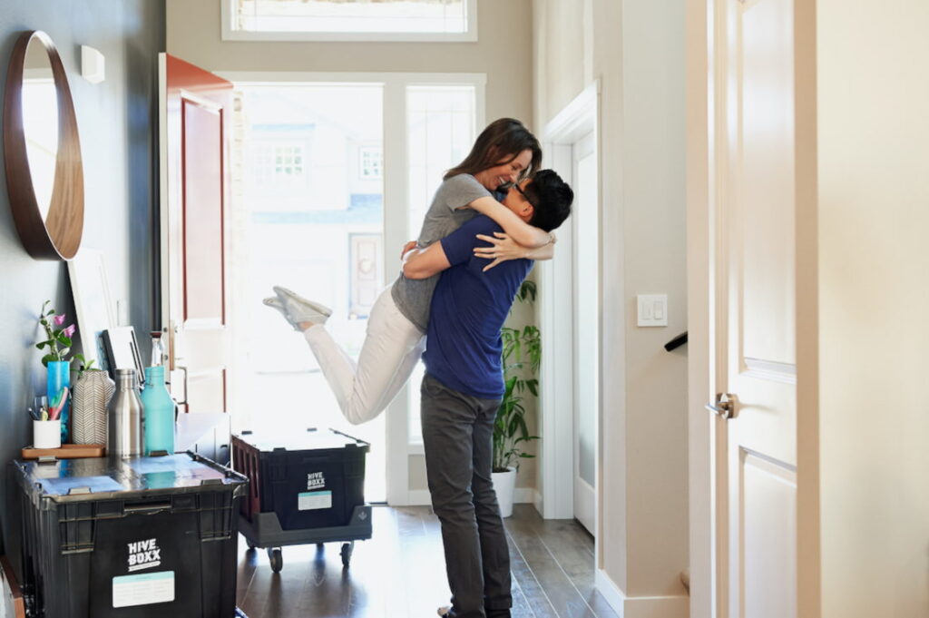 Um casal se abraça após a decisão da mudança entre uma casa ou apartamento.