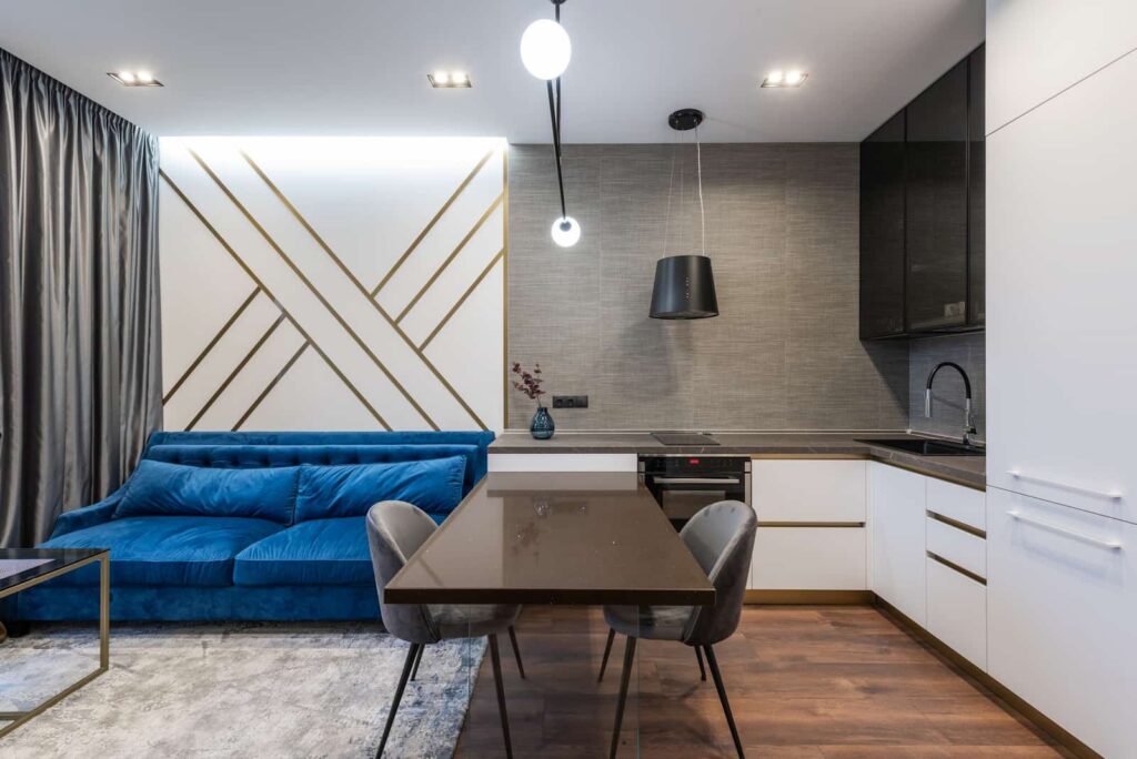 Um sofá azul tem uma tonalidade em contraste com os tons neutros da sala de estar, ponto marcante da decoração contemporânea