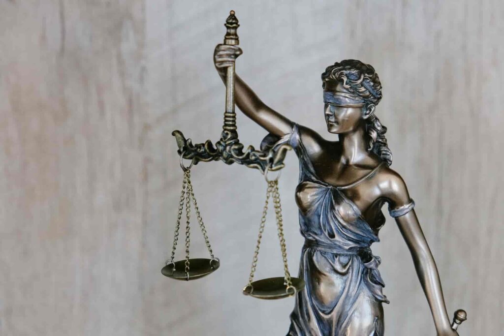 Na imagem, temos uma estátua de Thêmis, a deusa da justiça, representação das disputas judiciais, que podem ser reduzidas com a garantia de locação.