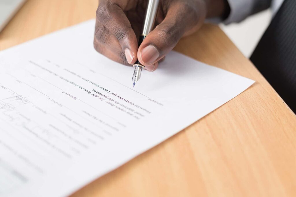 Um homem assina um contrato com garantia de locação na imagem.