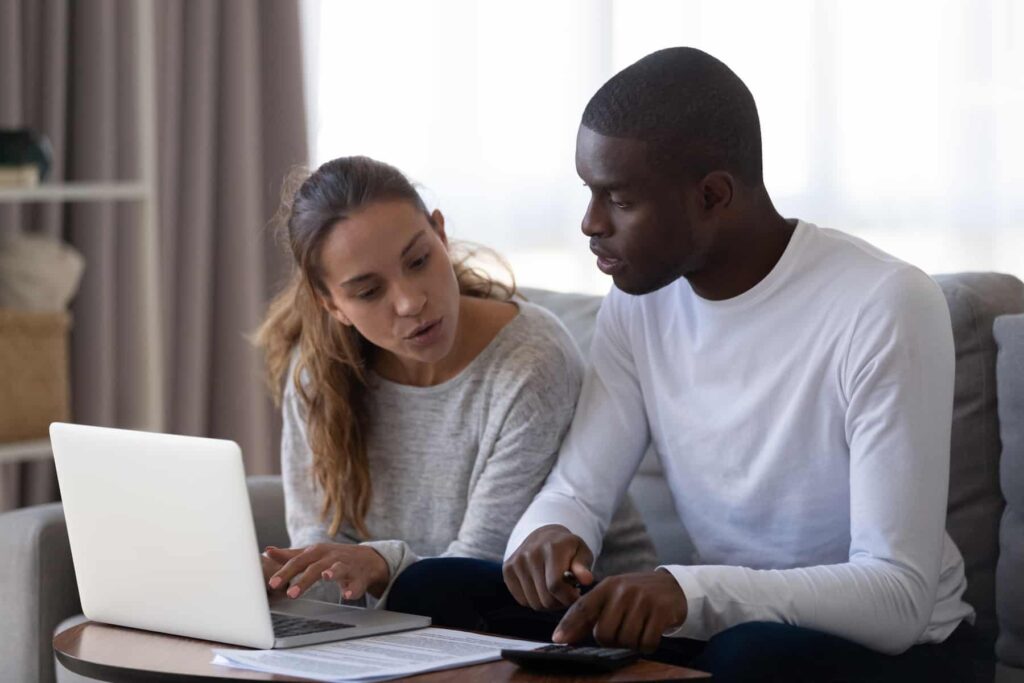 Um casal está lendo um contrato de locação em seu computador.
