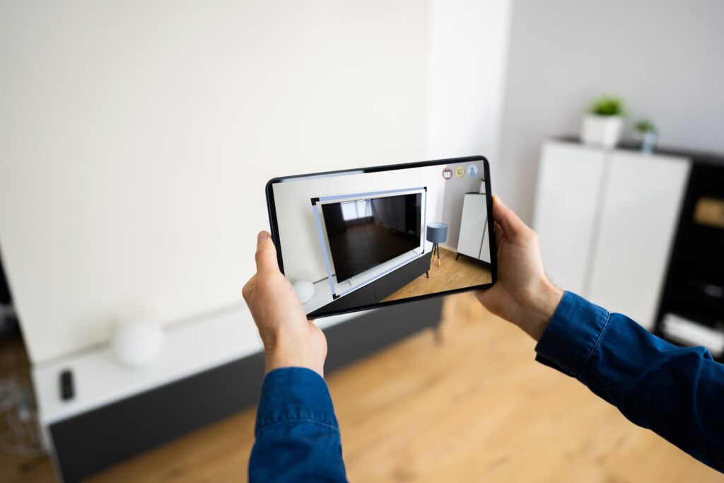 Uma pessoa está apontando um tablet com um sensor lidar para ver como sua nova TV ficará disposta na estante.